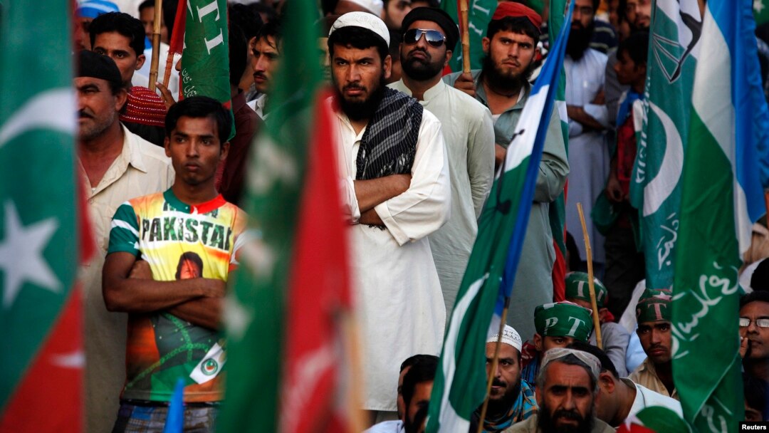 Supporters of Pakistani religious party Jamaat-e-Islami (JI) and the Pakistan Tehreek-e-Insaf (PTI) political party of former cricket star Imran Khan, listen to their leaders speak during a protest in Karachi, Nov. 24, 2013. 