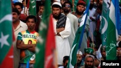 Supporters of Pakistani religious party Jamaat-e-Islami (JI) and the Pakistan Tehreek-e-Insaf (PTI) political party of former cricket star Imran Khan, listen to their leaders speak during a protest in Karachi, Nov. 24, 2013. 
