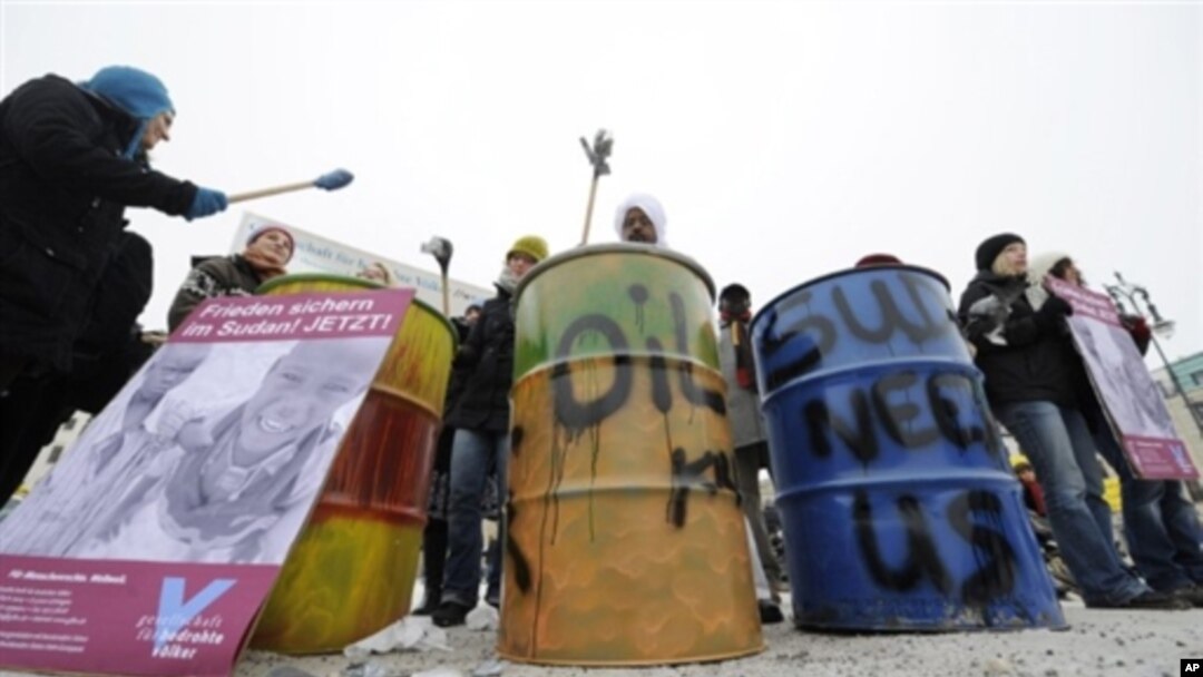 Activists bang oil drums during a protest by human rights advocates Amnesty International, to call attention to the allegedly worsening situation in Sudan, in Berlin 7 Jan 2010