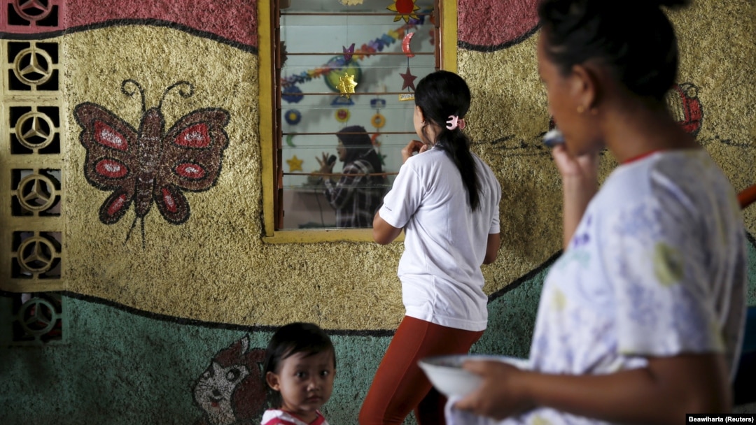 Para ibu menunggu anak-anaknya di sebuah taman kanak-kanak di kawasan Penjaringan, Jakarta. (Foto: REUTERS/Beawiharta)