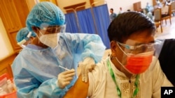 FILE - A man receives a COVID vaccine at a vaccination site, in Naypyitaw, Myanmar, Jan. 29, 2021, just days before a military coup threw the country into turmoil.