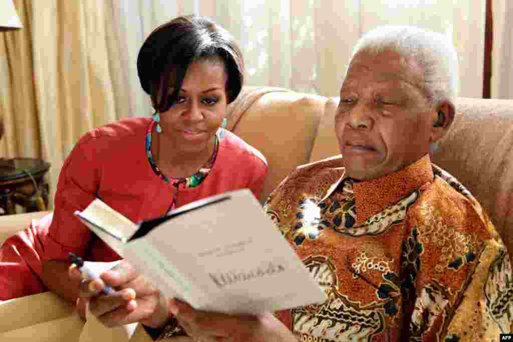 21 tháng 6: Đệ nhất phu nhân Hoa Kỳ Michelle Obama đến thăm cựu Tổng thống Nam Phi Nelson Mandela tại ngôi nhà của ông trong thành phố Houghton. (AP Photo/ Nelson Mandela Foundation)