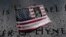 Rain drops rest near a U.S. flag with a picture of Walter Hynes at the south reflecting pool at the National 9/11 Memorial the day before the 19th anniversary of attacks in the Manhattan.