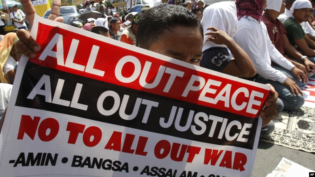 A Filipino Muslim flashes the peace sign as he holds a placard during a 'Prayer-for-Peace' rally near the Presidential Palace in Manila, Philippines, October 28, 2011. 