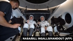 អវកាសយានិក​ពីររូប​របស់​អង្គការ​ណាសា គឺលោក Robert Behnken (ឆ្វេង) និង​លោក Douglas Hurley អង្គុយ​នៅ​ខាង​ក្នុង​យាន​អវកាស SpaceX Crew Dragon Endeavour បន្ទាប់ពី​បាន​ចុះចត​នៅ​ឈូងសមុទ្រ​ម៉ិកស៊ិក​នៅ​ឆ្នេរសមុទ្រ Pensacola នៃ​រដ្ឋ Florida នៅ​ថ្ងៃទី២ ខែសីហា ឆ្នាំ២០២០។