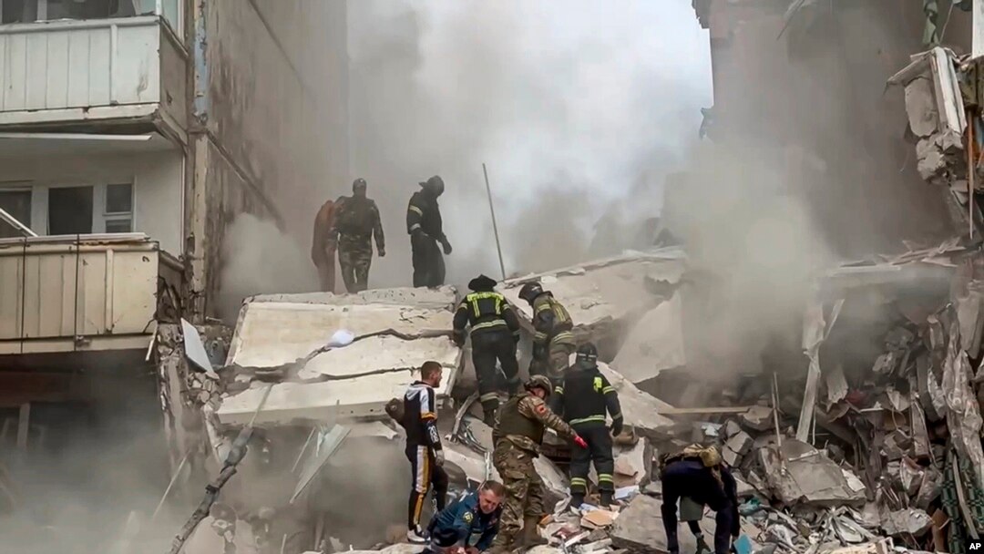 Empleados del servicio de emergencia ruso trabajan en un bloque de apartamentos que se derrumbó parcialmente después de un ataque con misiles de Ucrania en la ciudad rusa de Belgorod, Rusia, el 12 de mayo de 2024.