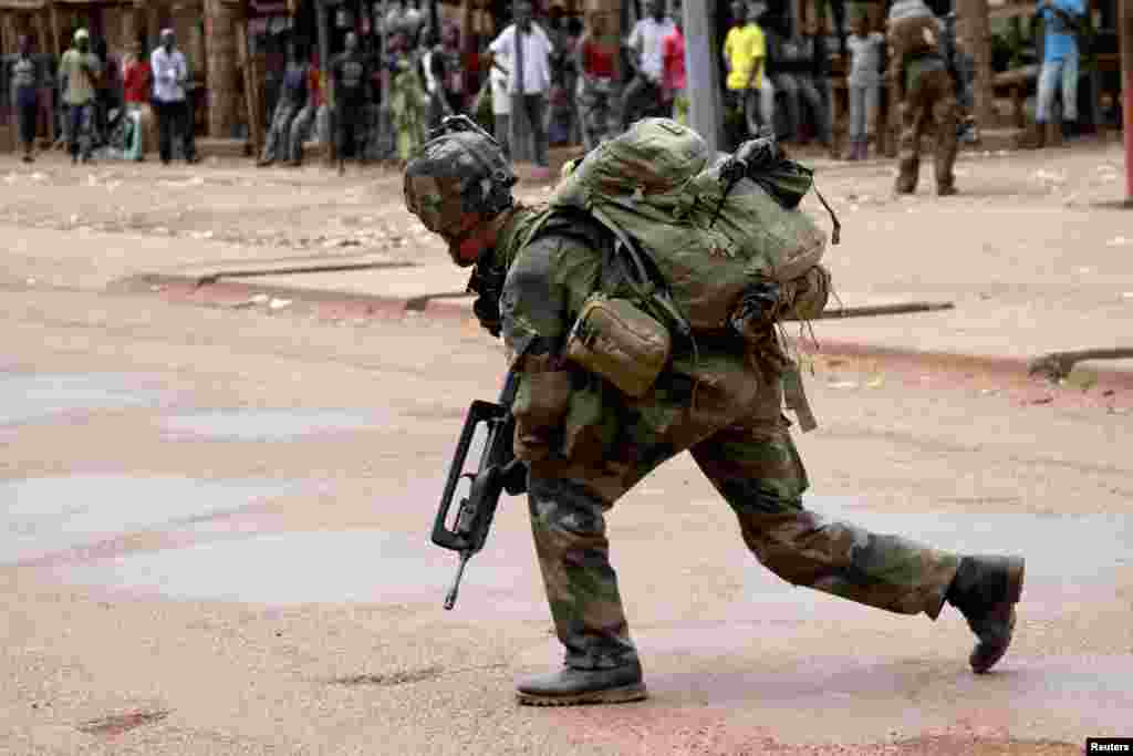 A French soldier crouches while on foot patrol in Bangui December 8, 2013.