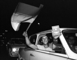 FILE - An East German refugee shows off a newly acquired West German passport just before crossing the Hungarian border into Austria, Sept. 10, 1989.