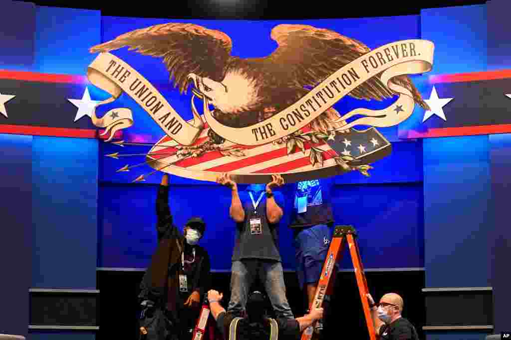 Workers adjust signage as preparations take place for the first Presidential debate in the Sheila and Eric Samson Pavilion, Sept. 28, 2020, in Cleveland,Ohio.