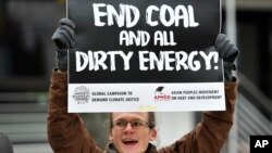 A protester holds a sign demanding to end coal burning during the 23rd Conference of the Parties (COP) climate talks in Bonn, Germany, Nov. 15, 2017.