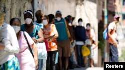 Archivo - Gente hace fila para recibir alimentos de un organización caritativa en Carapita, un barrio pobre de Caracas, Venezuela, el 30 de abril de 2020.