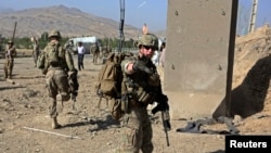 FILE - U.S. troops, part of the NATO-led International Security Assistance Force (ISAF), arrive at the site of a suicide attack in Maidan Shar, the capital of Wardak province, Afghanistan. 