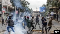 Manifestantes correm para se proteger enquanto agentes da polícia do Quénia disparam gás lacrimogéneo para impedir as pessoas de participarem numa manifestação planeada, convocada após um protesto que deixou mais de 20 mortos no centro de Nairobi