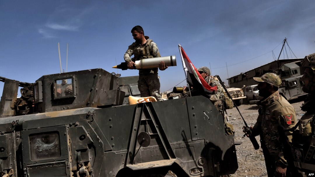 Anggota Divisi Reaksi Cepat membawa amunisi di kota Mosul sementara pasukan Irak memerangi jihadis di kota itu (26/2). (AFP/Aris Messinis)