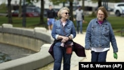 Donna Anderson, left, walks with her friend Christine White, Tuesday, April 27, 2021, in Olympia, Wash. (AP Photo/Ted S. Warren)