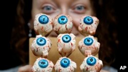 Cake Artist Sarah King displays her eyeball cakes at the 'Feed the Beast extreme cake shop' in London, Oct. 24, 2013. 