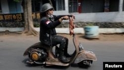 FILE - An extreme Vespa enthusiast rides his bike after attending weekend festival for extreme Vespas in Semarang, Central Java, Indonesia, July 22, 2018. 