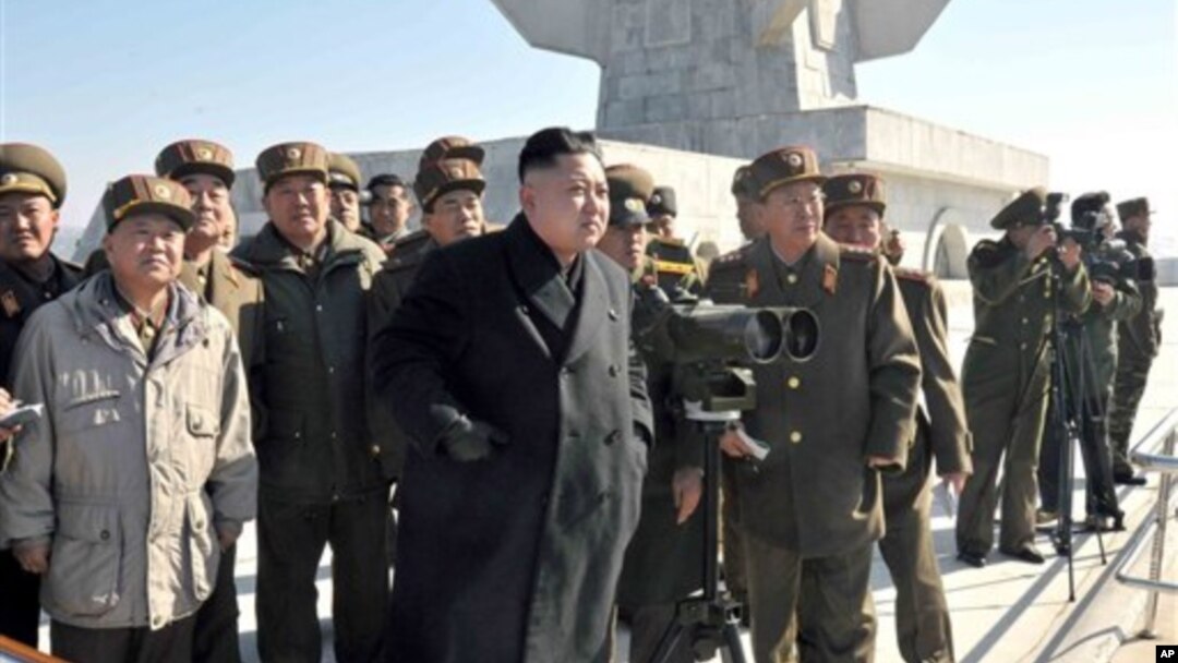 Pemimpin Korea Utara, Kom Jong Un meninjau latihan perang di sebuah lokasi pelatihan militer Korea Utara (14/3). Korea Utara menuduh Amerika dan sekutu Amerika menyerang situs-situs negaranya, termasuk KCNA, yang mengakibatkan sulitnya akses ke situs tersebut dalam waktu cukup lama pekan ini.