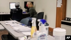 A job seeker, left, gets help from a staffer at Nebraska Heartland Workforce Solutions in Omaha, May 14, 2020. The number of Nebraskans filing new jobless claims appears to be stabilizing but is still higher than it was before the pandemic struck.