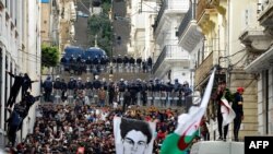 FILE - Algerian security forces form a human barrier as anti-government protesters take to the streets of the capital Algiers, as the Hirak pro-democracy movement gathers renewed momentum, Feb. 26, 2021.