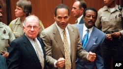 FILE - OJ Simpson reacts after he was found not guilty in the deaths of his ex-wife Nicole Brown Simpson and her friend Ron Goldman in Los Angeles. Defense attorneys F. Lee Bailey (left) and Johnnie L. Cochran Jr. stand with him.