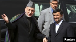 Afghan President Hamid Karzai (L) welcomes his Iranian counterpart Mahmoud Ahmadinejad upon his arrival in Kabul, March 10, 2010. 