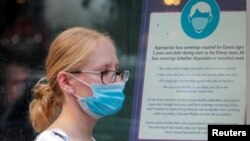A woman wears a mask against the coronavirus disease (COVID-19), following the CDC recommendation that fully vaccinated Americans wear masks as the highly transmissible Delta variant has led to a surge in infections, as she enters the Disney Store in Time