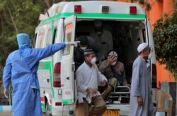 Indonesian tourists with Covid-19 symptoms get off from an ambulance at the Government Gandhi Hospital in Hyderabad, India, March 16, 2020.