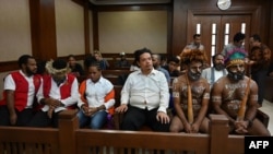Activists Dano Anes Tabuni, right, Ambrosius Mulait, 2nd right, Paulus Suryana Ginting, Arina Elopere, 3rd left, Charles Kossay, 2nd left, and Isay Wenda, left, wait for their trial in Jakarta, Jan. 20, 2020.