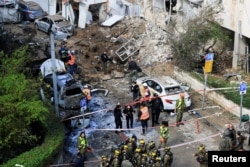 پرسنل امدادی در محل اصابت موشک پرتاب شده از مبدأ ایران در تل آویو