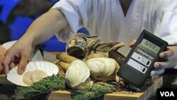 Produk makanan laut dari Jepang dipindai untuk mengetes kadar radiasinya di sebuah restoran di Hong Kong. Pemerintah mengubah posisi dengan memperketat pengawasan terhadap produk dari Jepang.