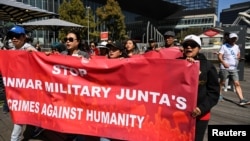 FILE - People hold a banner during a public rally held for the Myanmar community in Australia calling for ASEAN to not support the Myanmar military junta, outside the ASEAN-Australia Special Summit venue, in Melbourne, Australia, March 4, 2024.