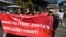 FILE - People hold a banner during a public rally held for the Myanmar community in Australia calling for ASEAN to not support the Myanmar military junta, outside the ASEAN-Australia Special Summit venue, in Melbourne, Australia, March 4, 2024.