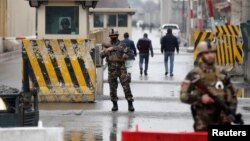 FILE - Afghan security forces keep watch at a check point near the site of a suicide attack in Kabul, Afghanistan, Feb. 24, 2018. 