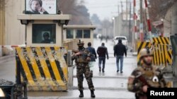 Afghan security forces keep watch at a check point near the site of a suicide attack in Kabul, Afghanistan, Feb. 24, 2018. 