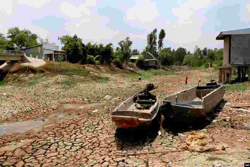 Two boats lie on cracked ground in a dry area in Ca Mau province, Vietnam. Vietnam is facing the most serious drought of the last 90 years, according to a statement by the Ministry of Agriculture and Rural Development.