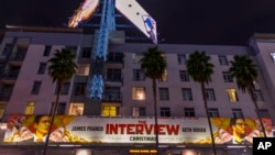 Spanduk Film "The Interview" dibentangkan di Arclight Cinemas, di Los Angeles. Sony Pictures di Amerika akhirnya mengubah keputusannya dan akan merilis “The Interview”, di bioskop-bioskop mulai 25 Desember. 