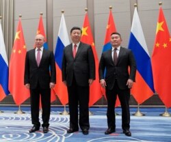FILE - Russian President Vladimir Putin, left, Chinese President Xi Jinping and President of Mongolia Khaltmaagiin Battulga pose for media during their meeting in Qingdao, China, June 9, 2018.