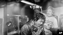 FILE - Los Angeles Dodgers pitcher Fernando Valenzuela is doused with champagne by teammate Tom Niedenfuer after the Dodgers won the National League title over the Expos, in Montreal, Oct. 20, 1981.