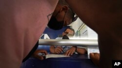 Migrantes compran boletos de autobús luego de recibir documentos que les permiten viajar legalmente por México, en Huixtla, estado de Chiapas, México, el viernes 10 de junio de 2022. 