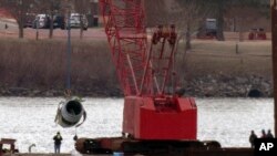 Rescue and salvage crews pull up a plane engine as cranes work near the wreckage of an American Airlines jet in the Potomac river from Ronald Reagan Washington National Airport, Feb. 3, 2025, in Arlington, Va. 