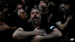 Iranian Shiite Muslims beat their chests during an Ashoura mourning ritual commemorating the 7th century martyrdom of Prophet Muhammad's grandson, Hussein, at the old main bazaar in Tehran on July 16, 2024.