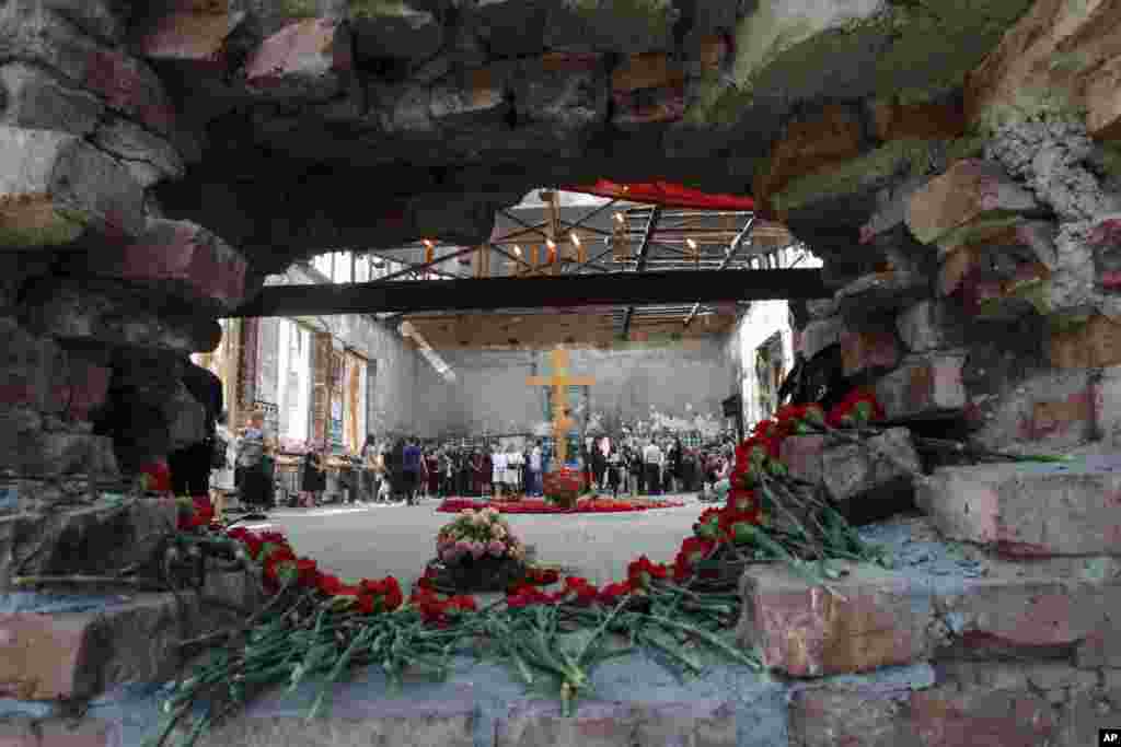 Flowers are laid in a hole in a wall as people gather in the gym of a school - the scene of the hostage crisis - in memory of victims on the 15th anniversary of the tragedy in Beslan, North Ossetia region, Russia.