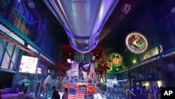 Guests pass by an exhibit under the nose of a Saturn V rocket at the Kennedy Space Center Visitor Complex Thursday, July 18, 2019, in Cape Canaveral, Florida.