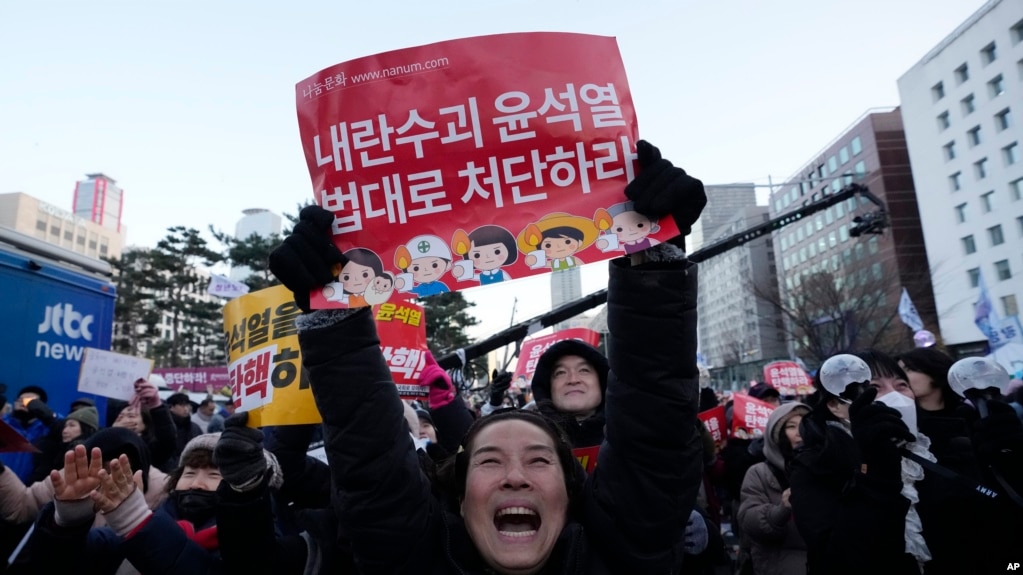 韩国首尔国会外头，集会民众听到韩国投票弹劾总统尹锡悦的消息后庆祝。(美联社：2024年12月14日)