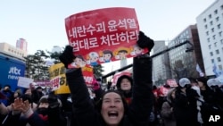 韩国首尔国会外头，集会民众听到韩国投票弹劾总统尹锡悦的消息后庆祝。(美联社：2024年12月14日)