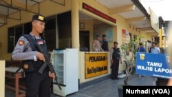 Polisi bersenjata lengkap dan memakai rompi anti peluru bersiaga di pos penjagaan Mapolresta Solo, Rabu, 13 November 2019. (Foto: VOA/Nurhadi)