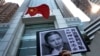 FILE - A placard with a photo of legal scholar Xu Zhiyong is raised by a demonstrator protesting against a Chinese court’s decision to sentence him in prison outside the Chinese liaison office in Hong Kong, Jan. 27, 2014.