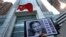 FILE - A placard with a photo of legal scholar Xu Zhiyong is raised by a demonstrator protesting against a Chinese court’s decision to sentence him in prison outside the Chinese liaison office in Hong Kong, Jan. 27, 2014.
