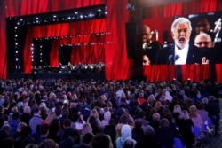 FILE - People listen to Spanish tenor Placido Domingo during a gala concert, dedicated to the upcoming World Cup, in Red Square in Moscow, Russia, June 13, 2018.